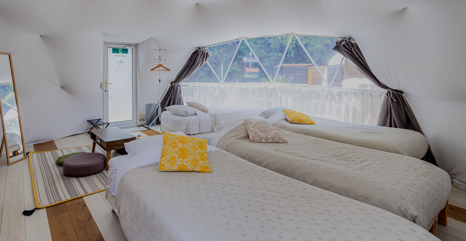 Spacious interior of a dome tent with three beds.
