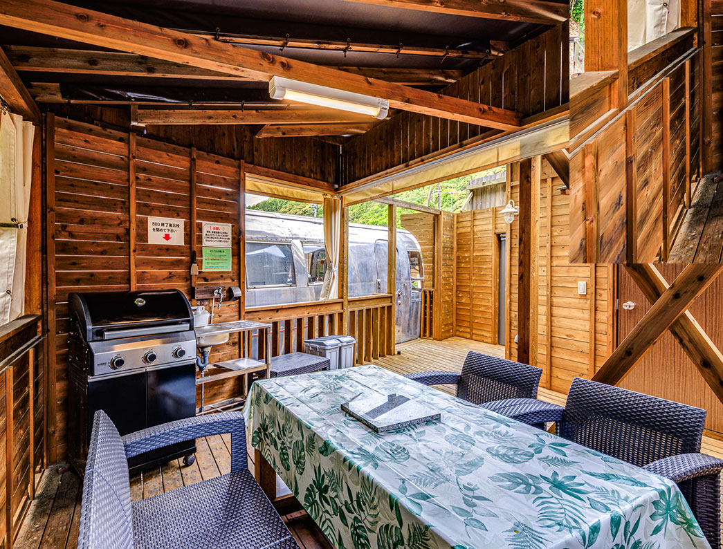 Covered wooden BBQ terrace attached to a trailer house.